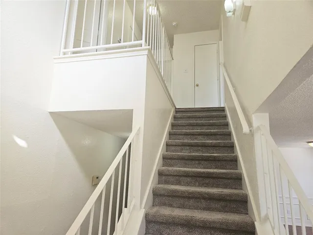 a view of staircase with wooden floor and white walls