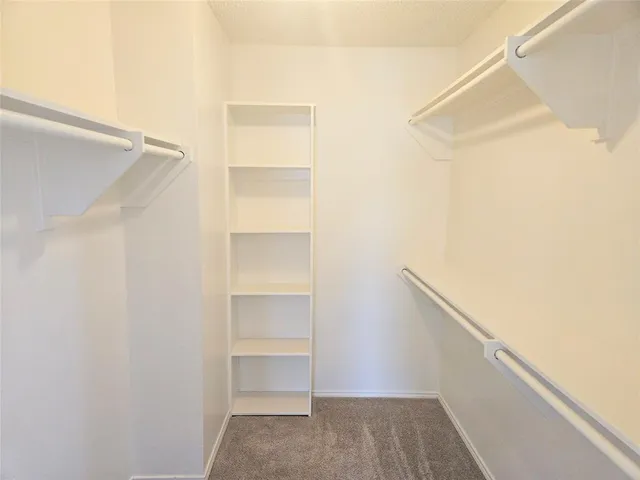 a view of walk in closet with empty racks