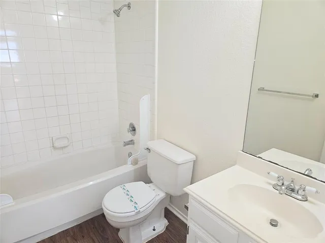 a white toilet sitting next to a bath tub