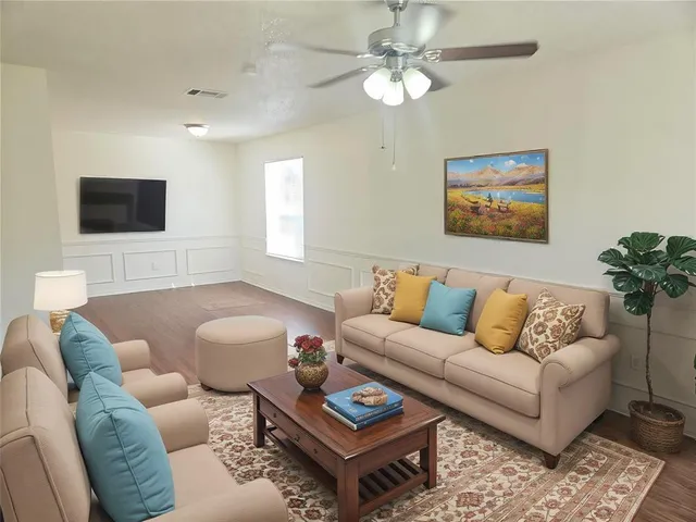 a living room with furniture a flat screen tv and a window