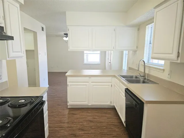 a kitchen with a sink stove top oven and cabinets