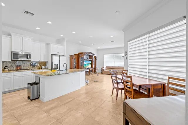 a kitchen with stainless steel appliances kitchen island granite countertop a sink and a refrigerator