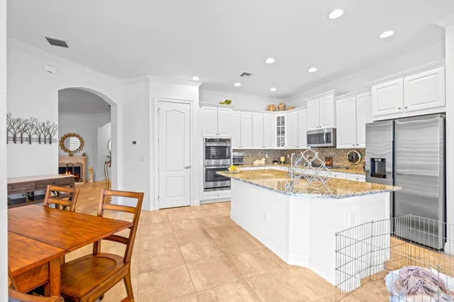 an open kitchen with stainless steel appliances kitchen island granite countertop a stove and a sink