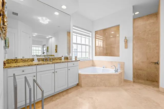 a spacious bathroom with a tub sink and mirror
