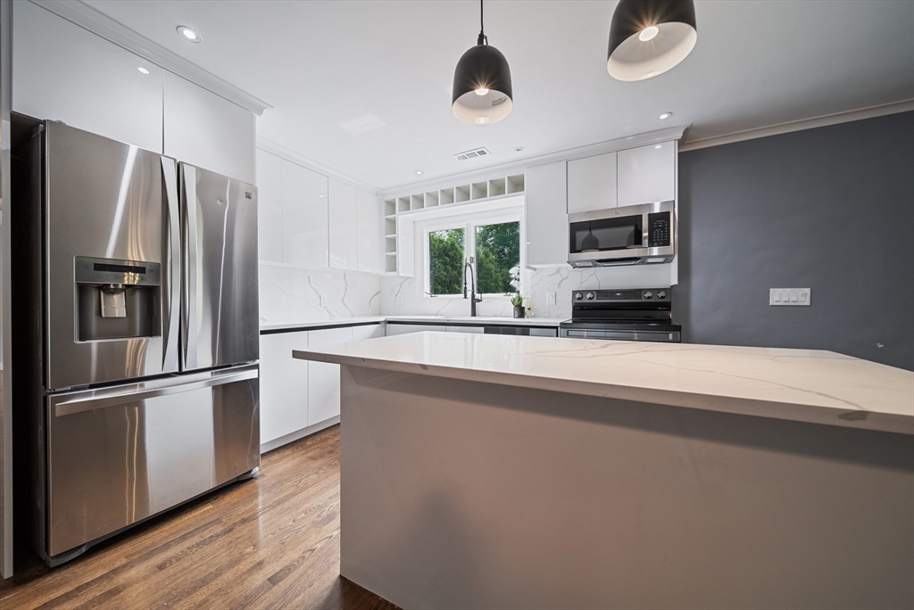 123 Walnut Street Saugus, MA 01906 - Photo 6 of 38 a kitchen with kitchen island a counter space stainless steel appliances and cabinets