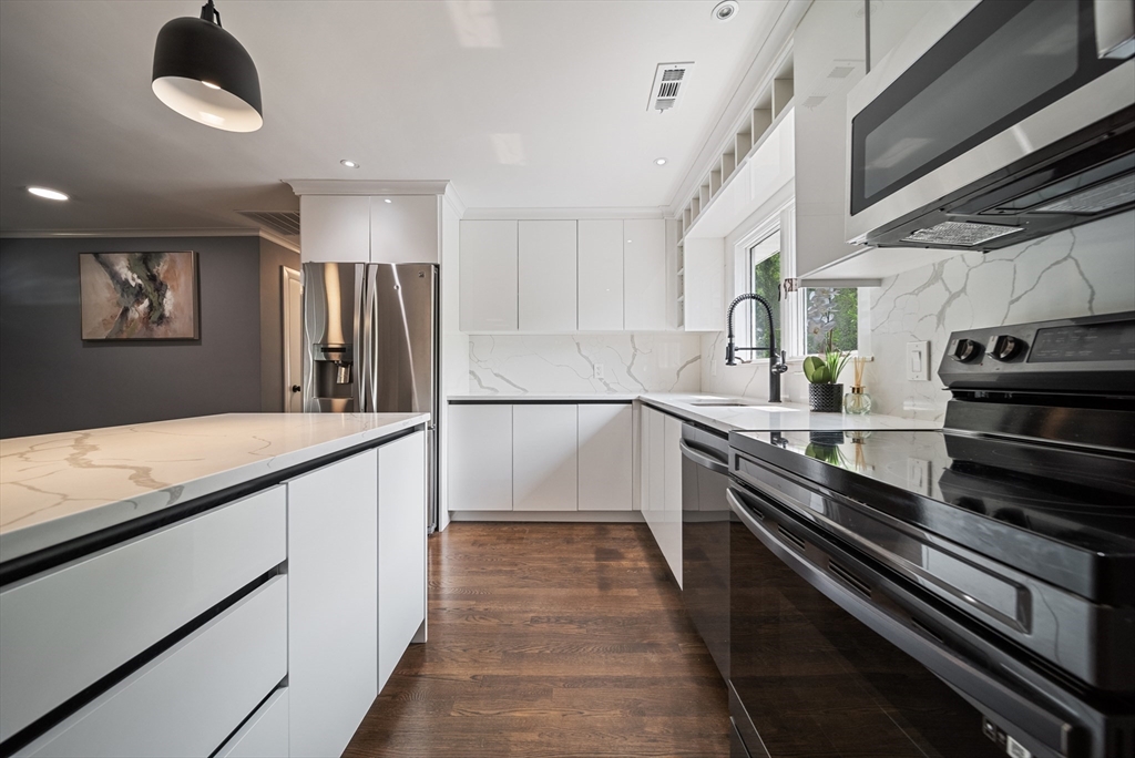 123 Walnut Street Saugus, MA 01906 - Photo 8 of 38 a large kitchen with stainless steel appliances granite countertop a lot of cabinets and wooden floor