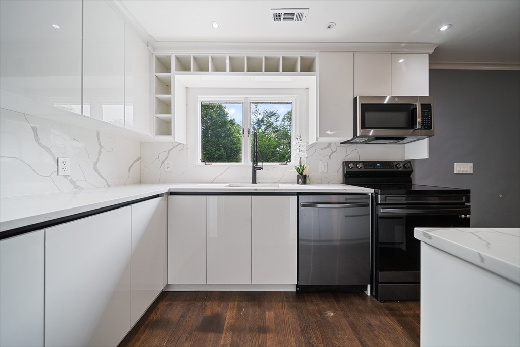 123 Walnut Street Saugus, MA 01906 - Photo 9 of 38 a kitchen with granite countertop a stove a sink and a microwave