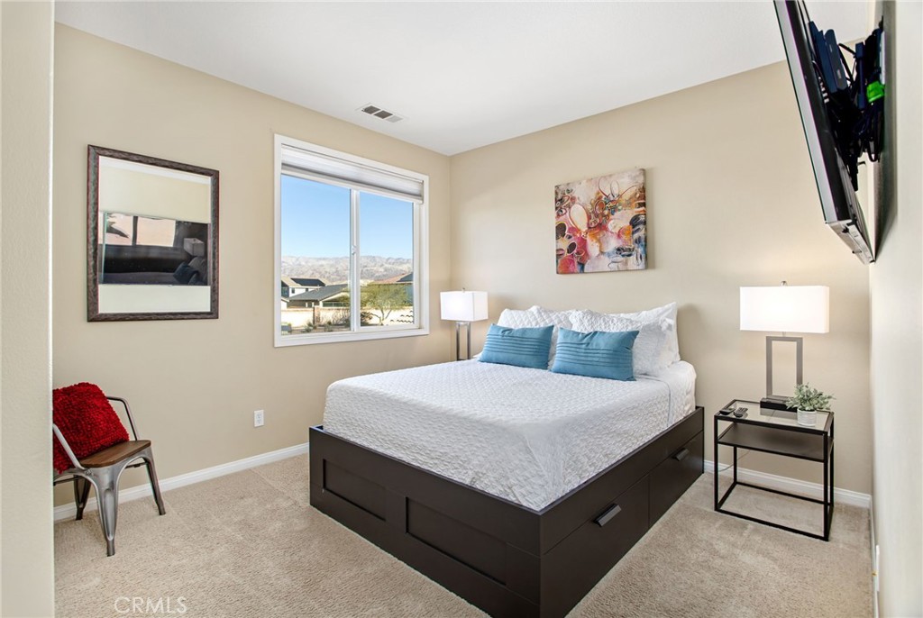 84146 Olona Court Indio, CA 92203 - Photo 20 of 35 a bedroom with a bed a painting on the wall and a window