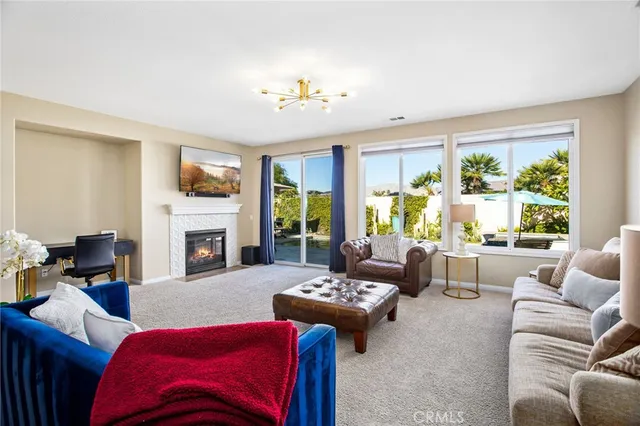 a living room with furniture fireplace and a large window