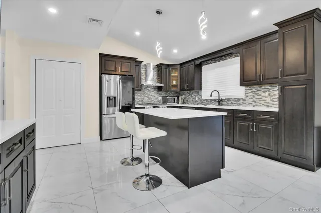 a kitchen with a sink refrigerator and cabinets
