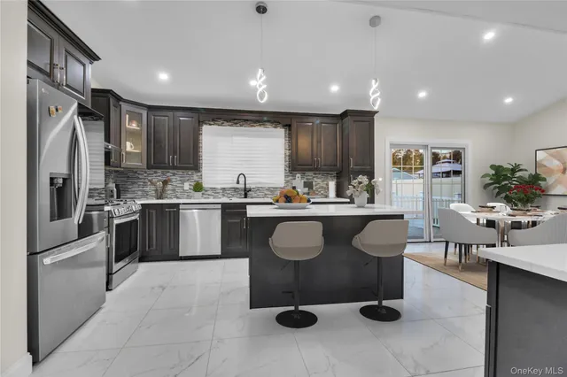 a kitchen with stainless steel appliances granite countertop a sink a stove and cabinets