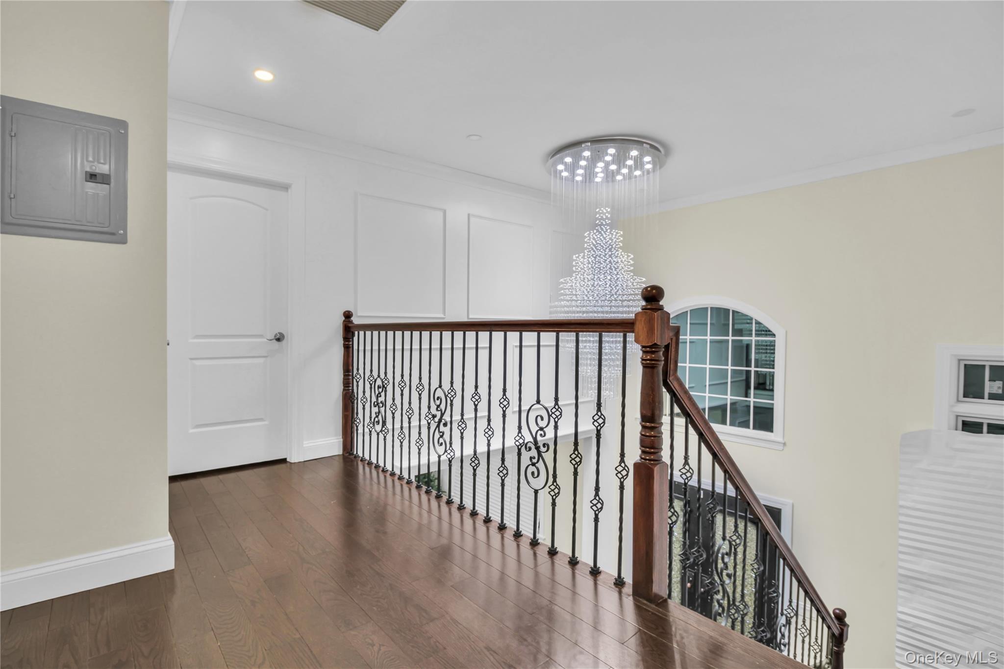 858 Prescott Street Valley Stream, NY 11580 - Photo 17 of 48 Hall featuring electric panel, dark wood finished floors, an upstairs landing, a chandelier, and ornamental molding