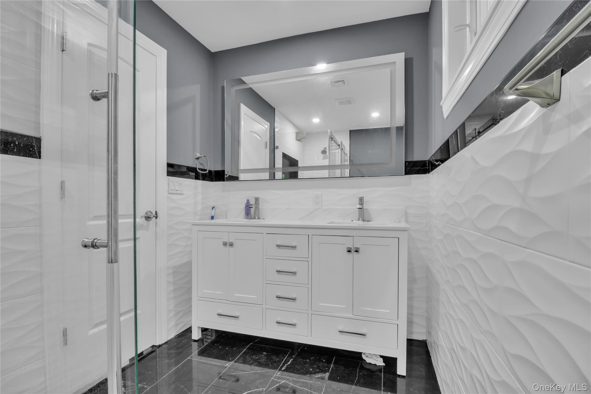 858 Prescott Street Valley Stream, NY 11580 - Photo 29 of 48 Full bathroom featuring tile walls, double vanity, a shower stall, and dark marble finish flooring