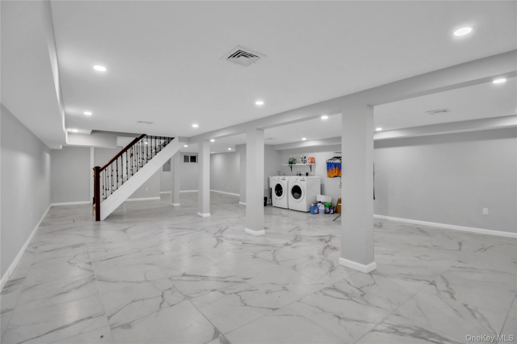 858 Prescott Street Valley Stream, NY 11580 - Photo 32 of 48 Finished below grade area featuring light marble finish flooring, independent washer and dryer, recessed lighting, and stairway