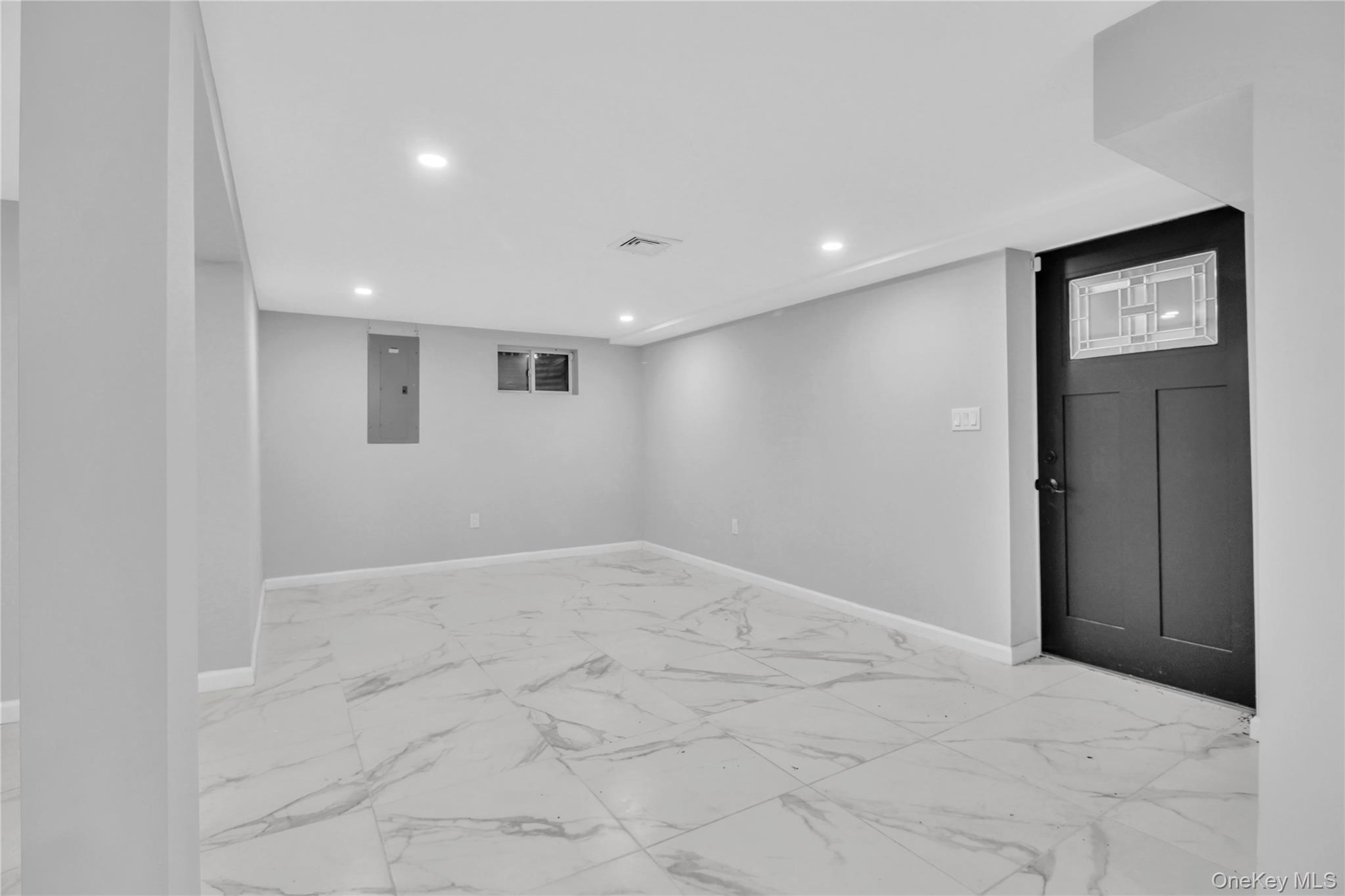 858 Prescott Street Valley Stream, NY 11580 - Photo 35 of 48 Finished below grade area with light marble finish floors, recessed lighting, and electric panel