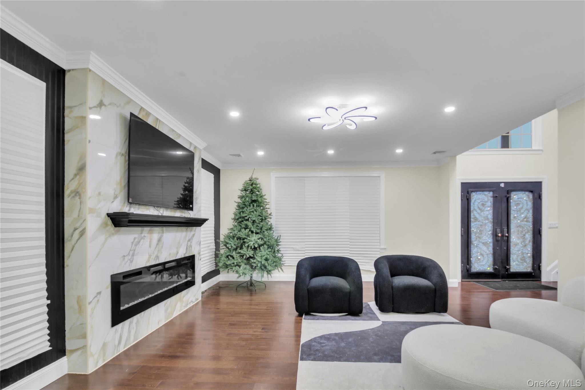 858 Prescott Street Valley Stream, NY 11580 - Photo 5 of 48 Living room with crown molding, an accent wall, dark wood-type flooring, a fireplace, and french doors