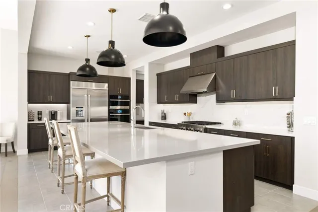 a large kitchen with stainless steel appliances lots of counter space and a sink