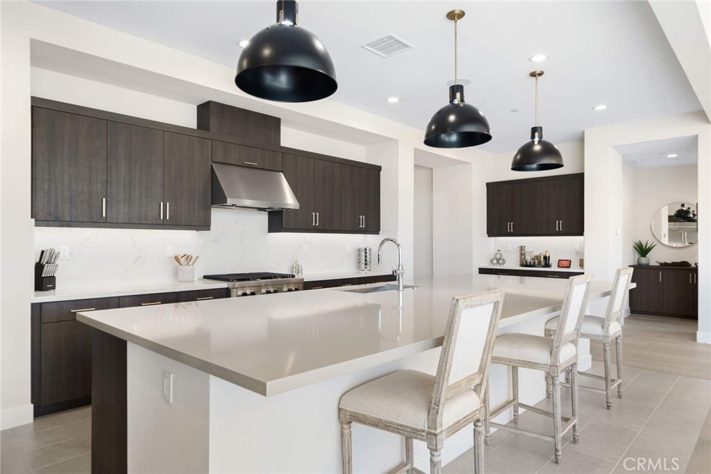 80467 Old Ranch Trail South La Quinta, CA 92253 - Photo 13 of 55 a kitchen with stainless steel appliances a stove a chandelier and a refrigerator
