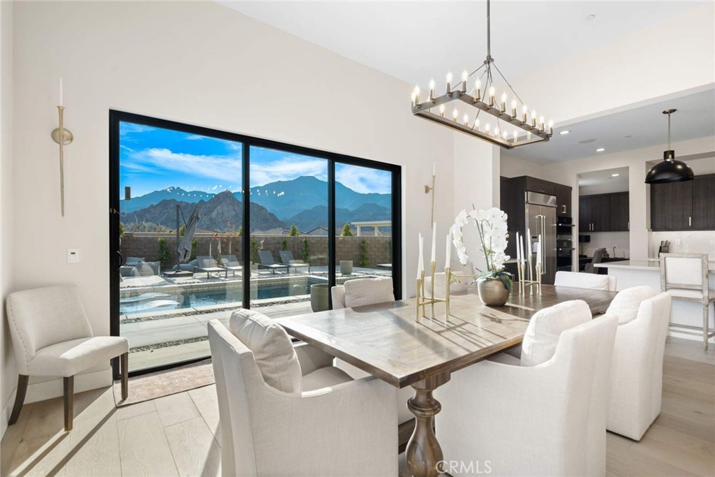 80467 Old Ranch Trail South La Quinta, CA 92253 - Photo 22 of 55 a view of a dining room with furniture large windows and a chandelier