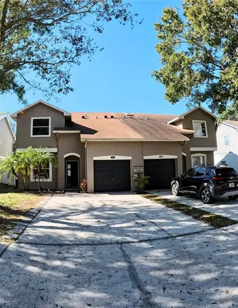 a view of house with yard and trees in the background