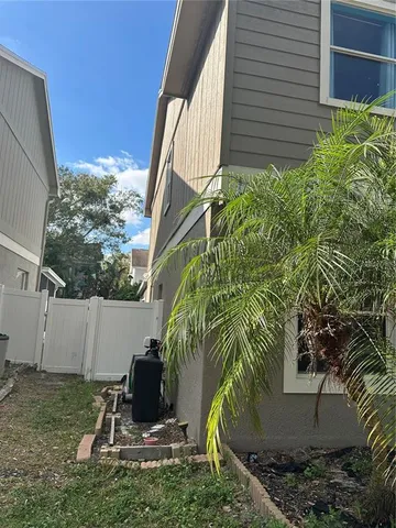 a view of a backyard with plants and a bench