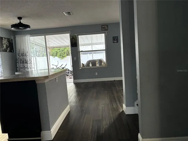 a view of a hallway with wooden floor and a window