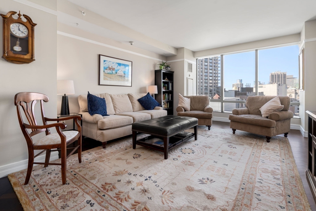 1 Avery Street, Unit 16G Boston, MA 02111 - Photo 3 of 15 a living room with furniture a rug and a large window