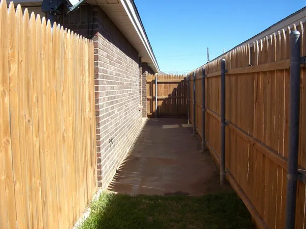 a view of a pathway with a wooden fence