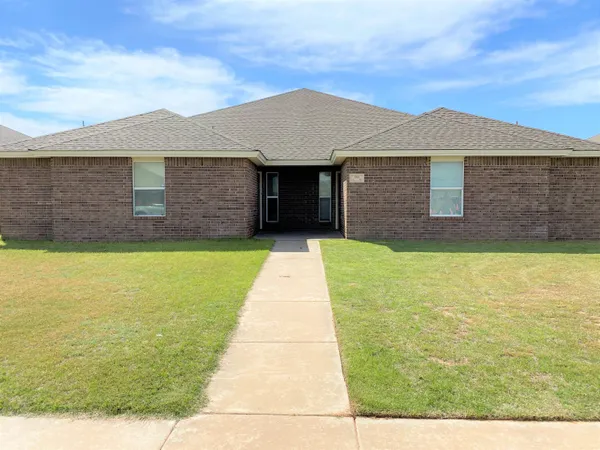 a view of a brick house with a yard