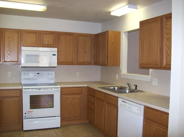 a kitchen with granite countertop cabinets stainless steel appliances and wooden cabinets