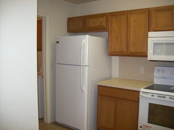 a view of a kitchen with sink and refrigerator