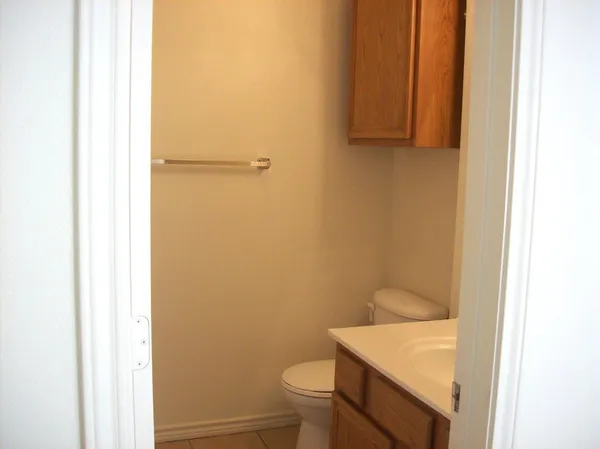 a bathroom with a granite countertop toilet and a sink