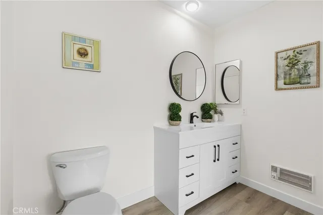 a bathroom with a toilet sink vanity and mirror
