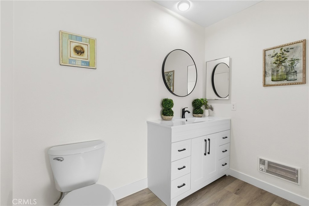 300 North Rampart Street, Unit 152 Orange, CA 92868 - Photo 17 of 29 a bathroom with a toilet sink vanity and mirror