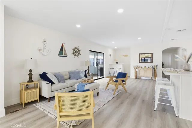 a living room with furniture a wooden floor and white walls