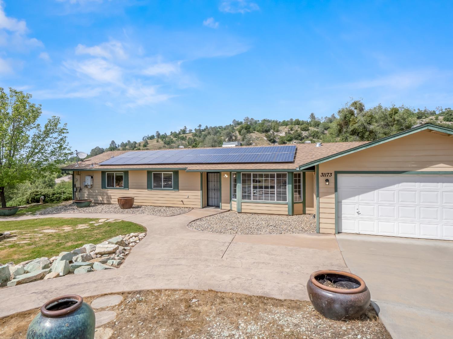 31173 Moccassin Way Coarsegold, CA 93614 - Photo 3 of 48 a front view of a house with a garden and yard