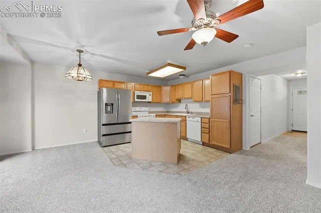 a kitchen with stainless steel appliances granite countertop a stove a sink dishwasher and a refrigerator with wooden floor