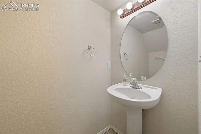 an empty room with chandelier fan and fireplace