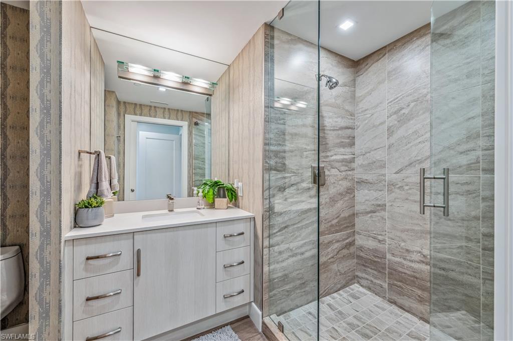 13915 Old Coast Road, Unit 2004 Naples, FL 34110 - Photo 14 of 29 a bathroom with a double vanity sink mirror and shower