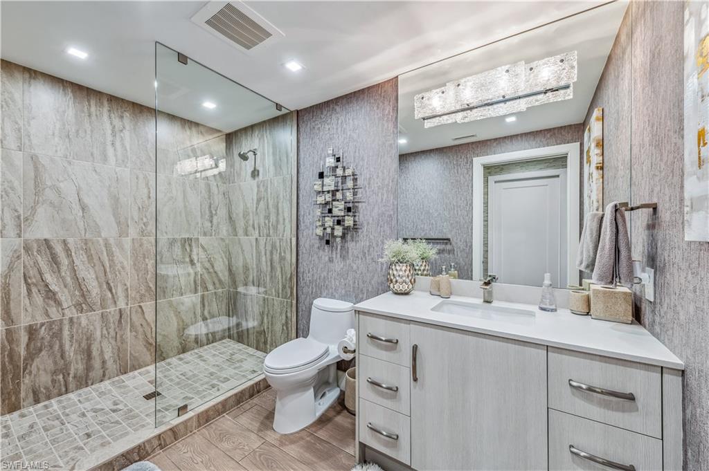 13915 Old Coast Road, Unit 2004 Naples, FL 34110 - Photo 16 of 29 a bathroom with a double vanity sink mirror and toilet