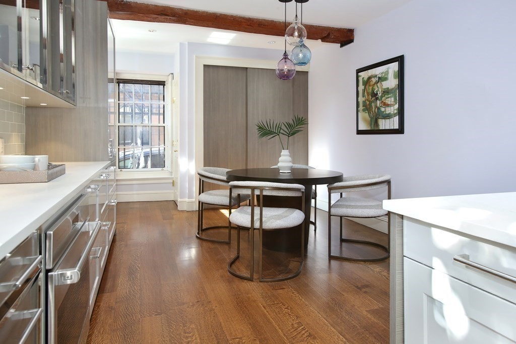 14 Walnut Street Boston, MA 02108 - Photo 17 of 42 a dining room with wooden floor a glass table and chairs