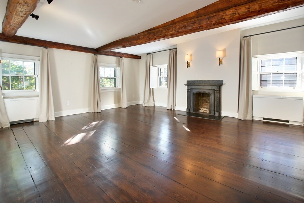 14 Walnut Street Boston, MA 02108 - Photo 32 of 42 an empty room with wooden floor fireplace and windows