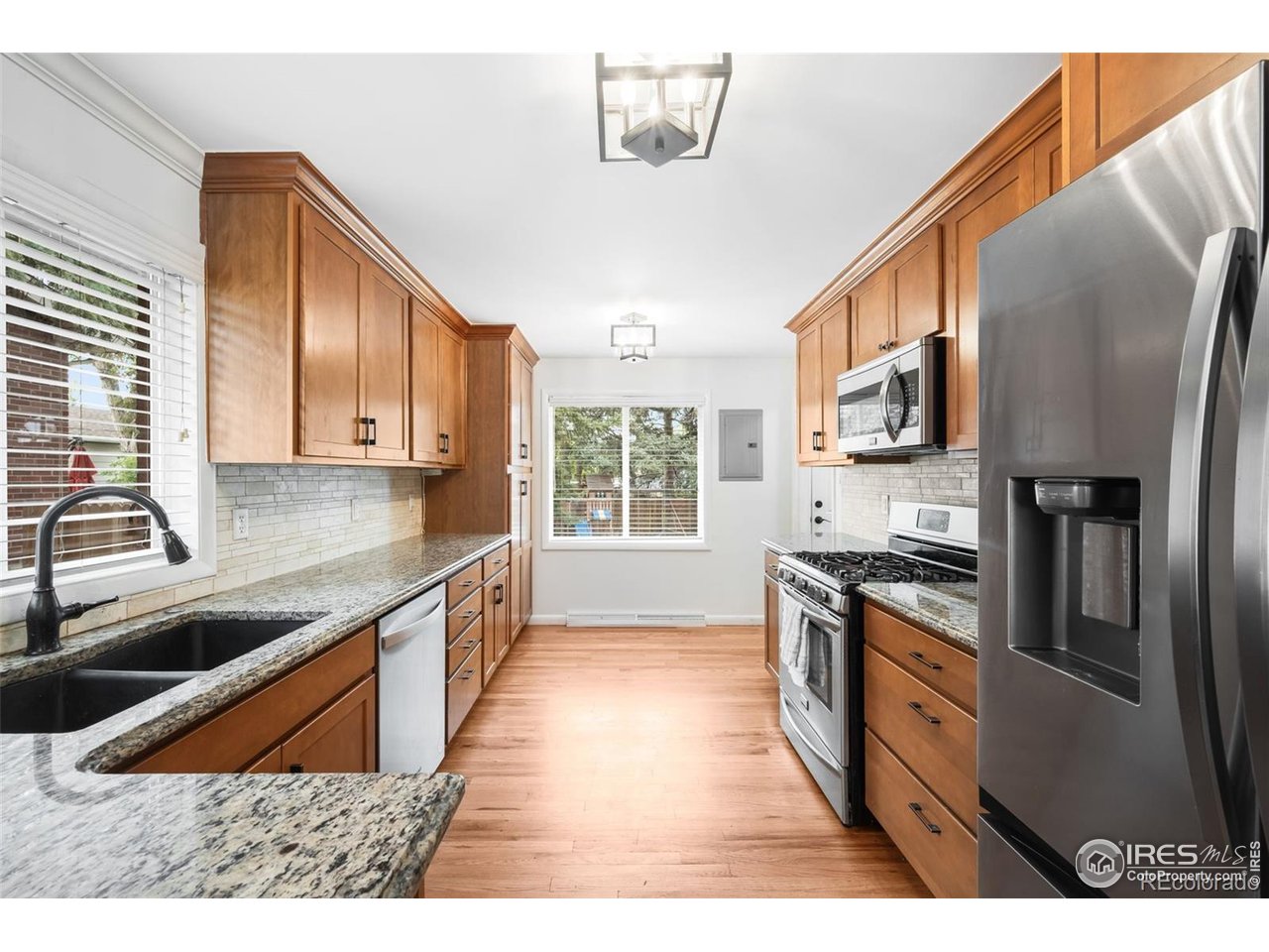 4175 South Inca Street Englewood, CO 80110 - Photo 7 of 29 a kitchen with granite countertop a sink a counter top space stainless steel appliances and cabinets