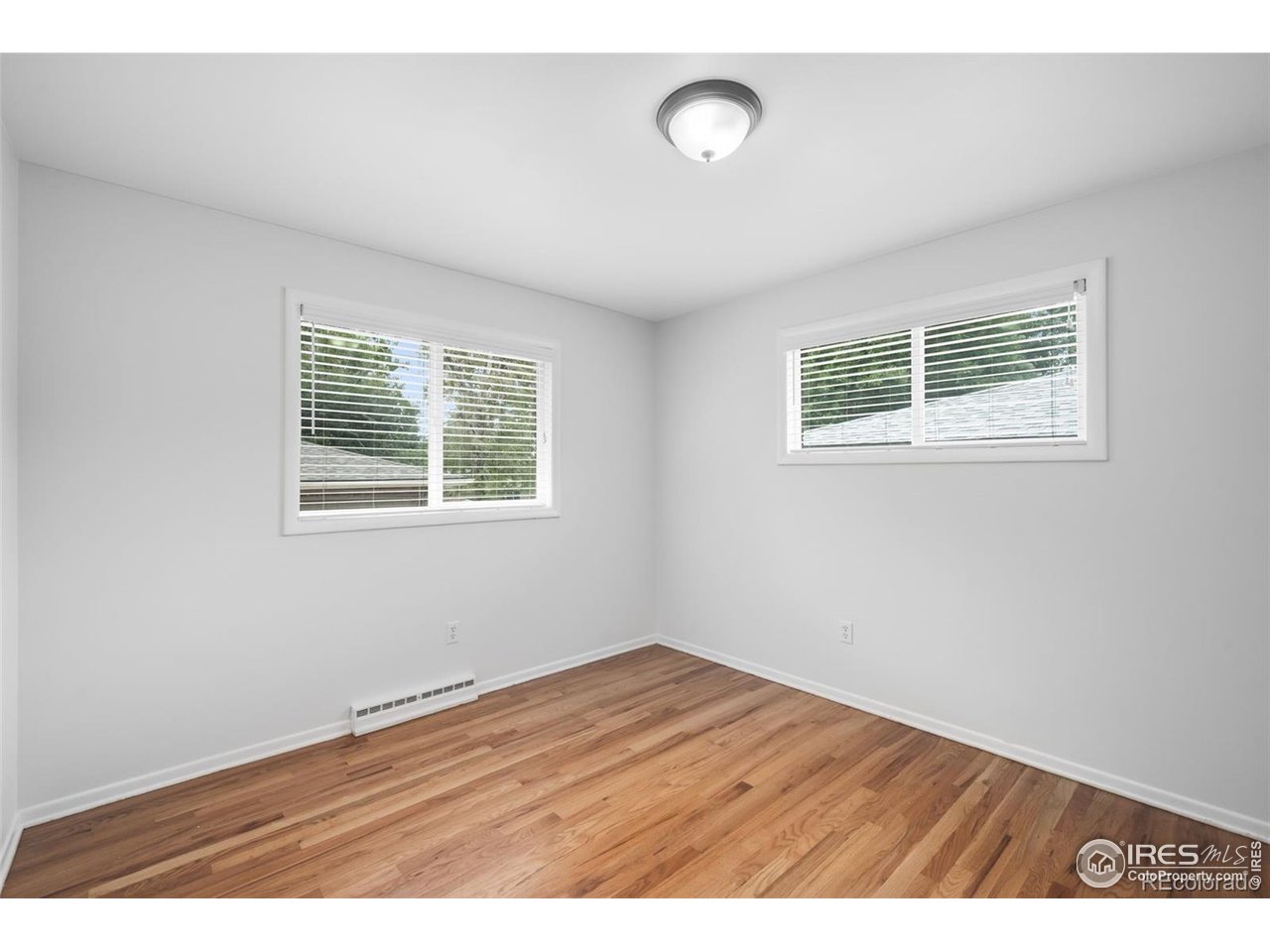 4175 South Inca Street Englewood, CO 80110 - Photo 9 of 29 an empty room with wooden floor and windows