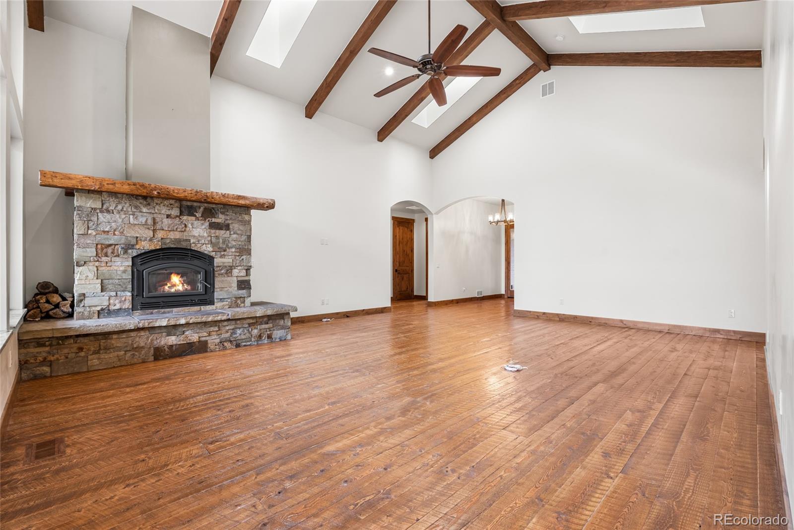 280 Double Tree Road Bailey, CO 80421 - Photo 7 of 43 a view of empty room with wooden floor and fireplace