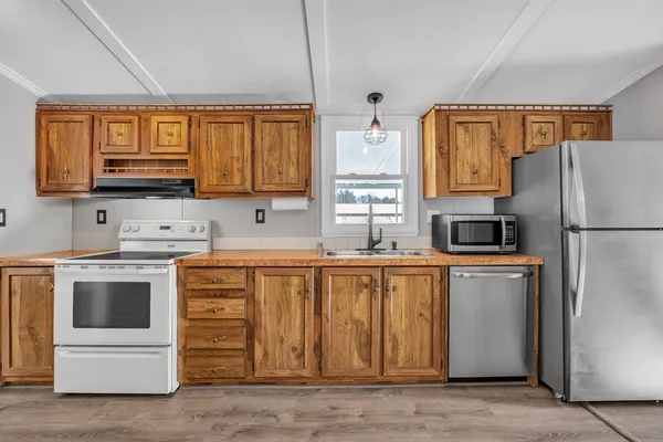 a kitchen with stainless steel appliances a refrigerator sink and cabinets