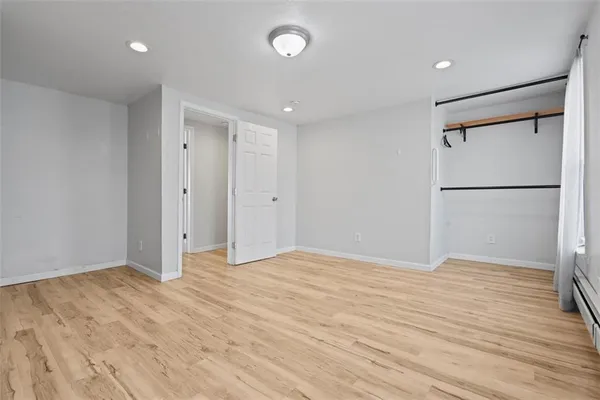 a view of empty room with wooden floor
