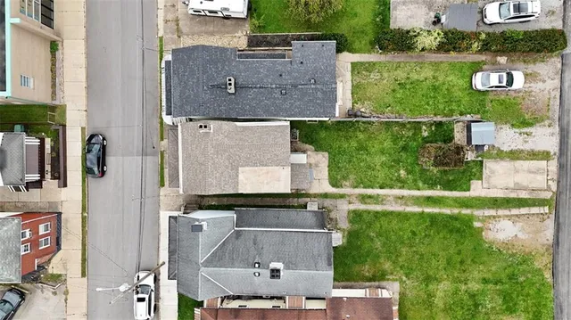 an aerial view of residential houses with outdoor space and parking