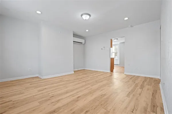 a view of an empty room with wooden floor