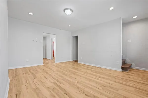 a view of an empty room with wooden floor